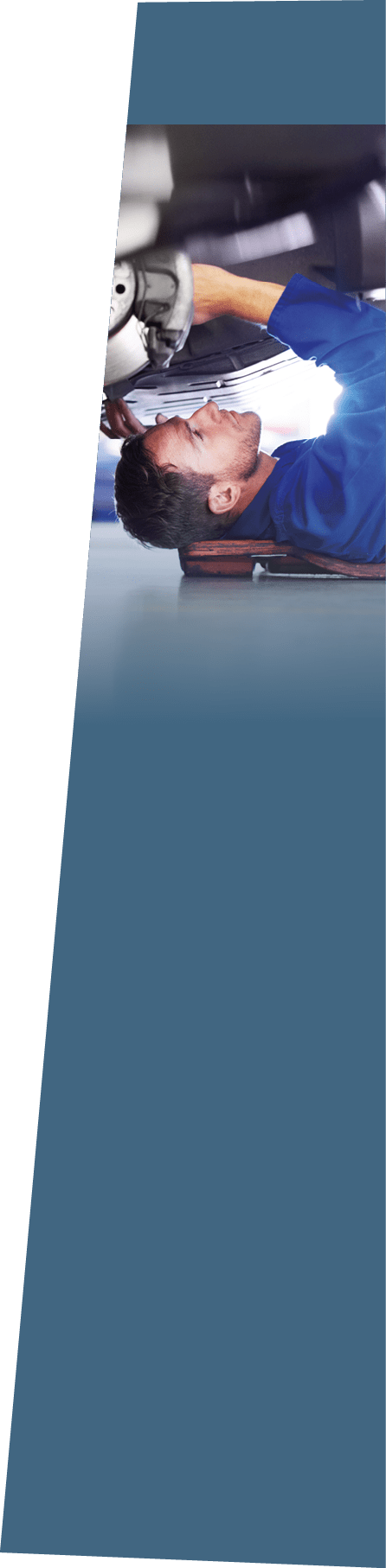 A car mechanic working on the underside of a car